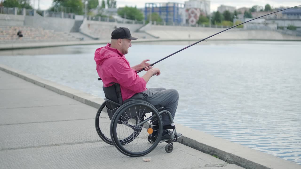 persona con discapacidad física que utiliza silla de ruedas para pescar en el muelle de pesca