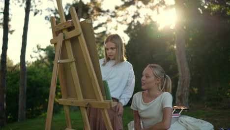 two girls painting outdoors