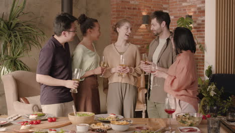 a multicultural group of friends chatting and having fun at a dinner party