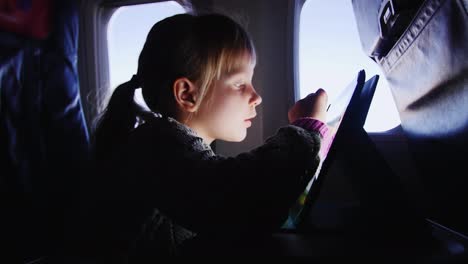 a girl enjoys the tablet in the aircraft