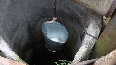 an empty bucket slowly sinks into the well.