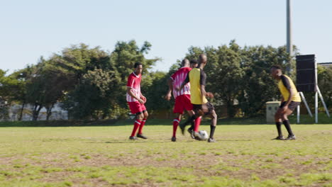 playing soccer, male players tackling and competing for ball on field