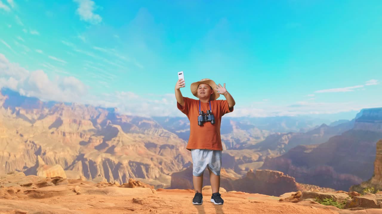 Asian Boy With A Hat And Binoculars Waving Hand Having Video Call On Smartphone While Traveling At The Top Of Mountain. Boy Researcher Examines Something, Travel Adventure, Full Body