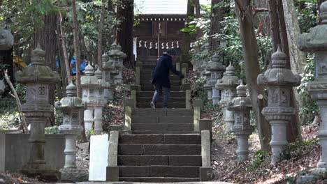 a caucasian guy reaches the top of the ladder at a japanese traditional temple on daytime