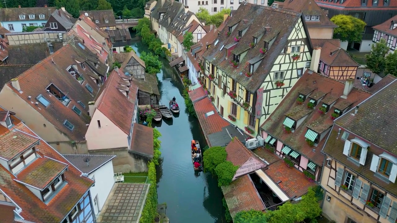 Video drone 4K aereo di turisti in barca sul fiume Lauch nella zona della Piccola Venezia a Colmar, Francia.