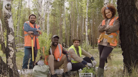 group of multiethnic ecologist activists posing for the camera in the forest