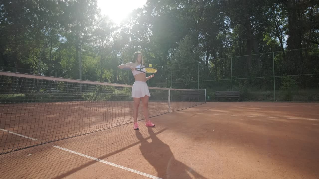 여자 테니스 선수 가 야외 코트 에서 세브 를 연습 하고 있다