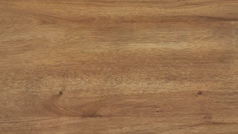 camera zooms slowly, revealing fine wood grain across tabletop