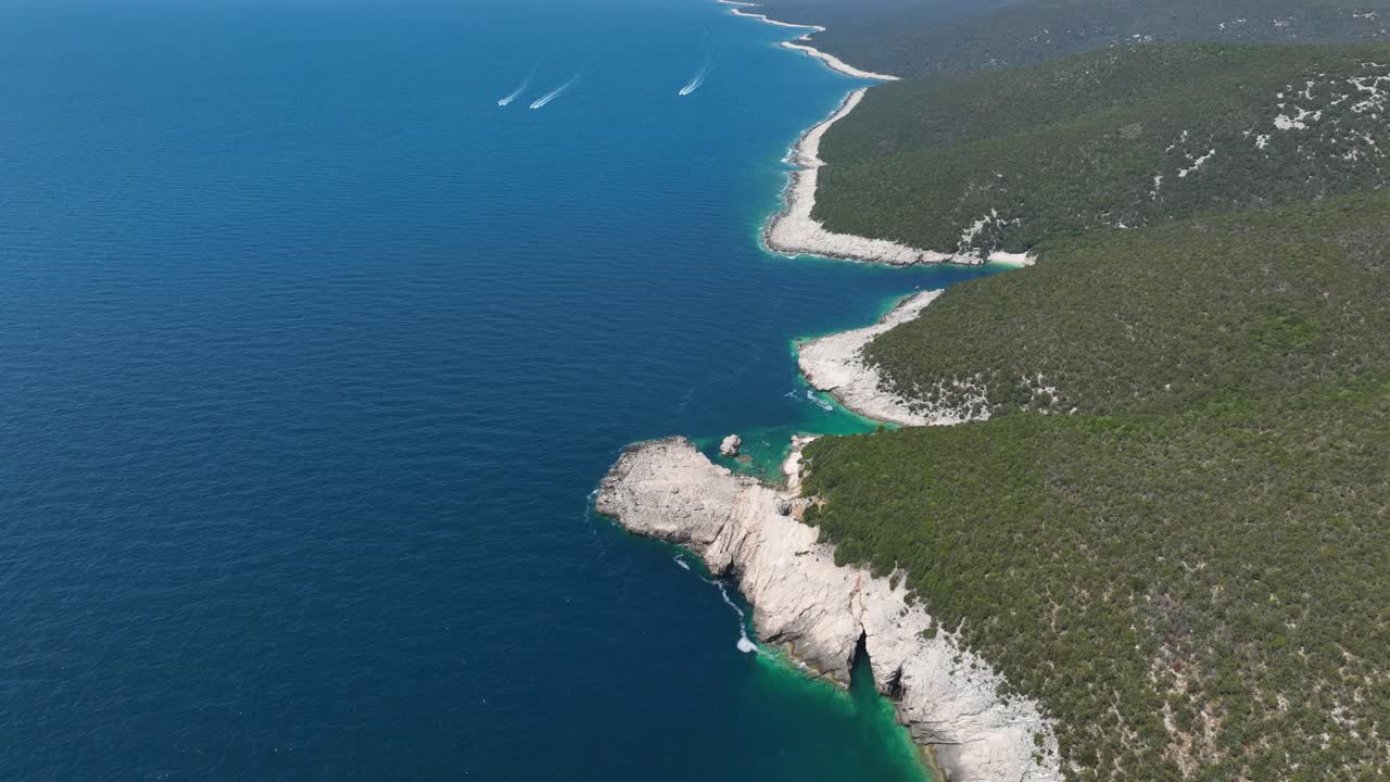 Dugi Otok -saaren rantaviiva, jossa on rosoiset valkoiset kalliot, kasvillisuus ja syvän siniset vedet, Kroatia