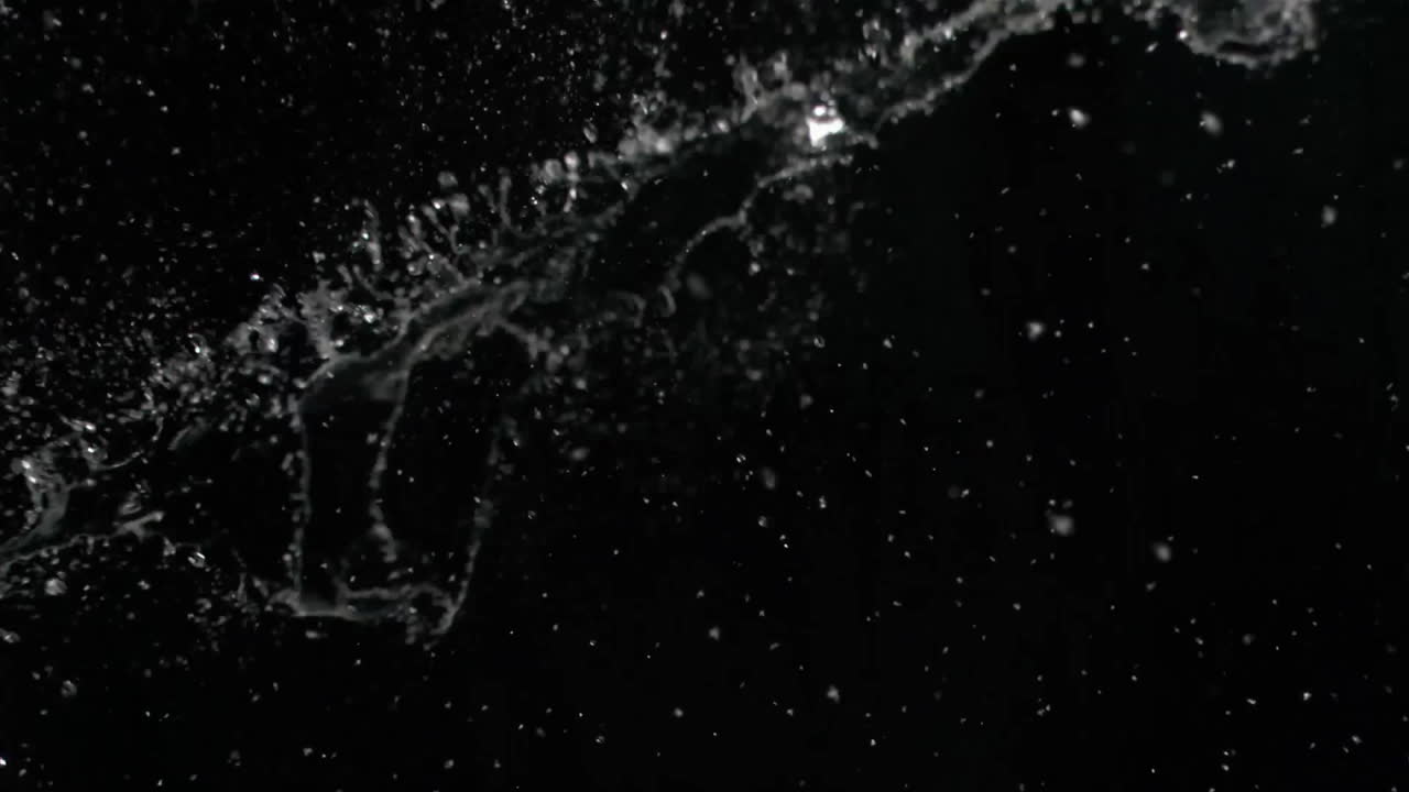animación de salpicaduras de agua sobre fondo negro con gotas dispersas