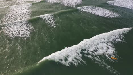 Vista-Aérea-De-Surfista-Montando-Olas-En-Una-Playa-Tropical