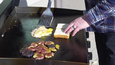 voltear huevo, queso y jamón para hacer un sándwich de desayuno de tostadas de texas - cámara lenta aislada