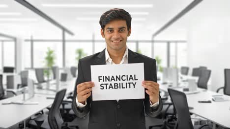 happy indian manager holding financial stability banner