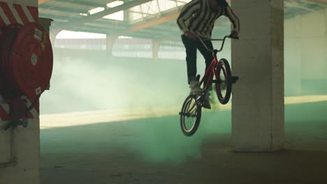 bmx riders in an empty warehouse using smoke grenade