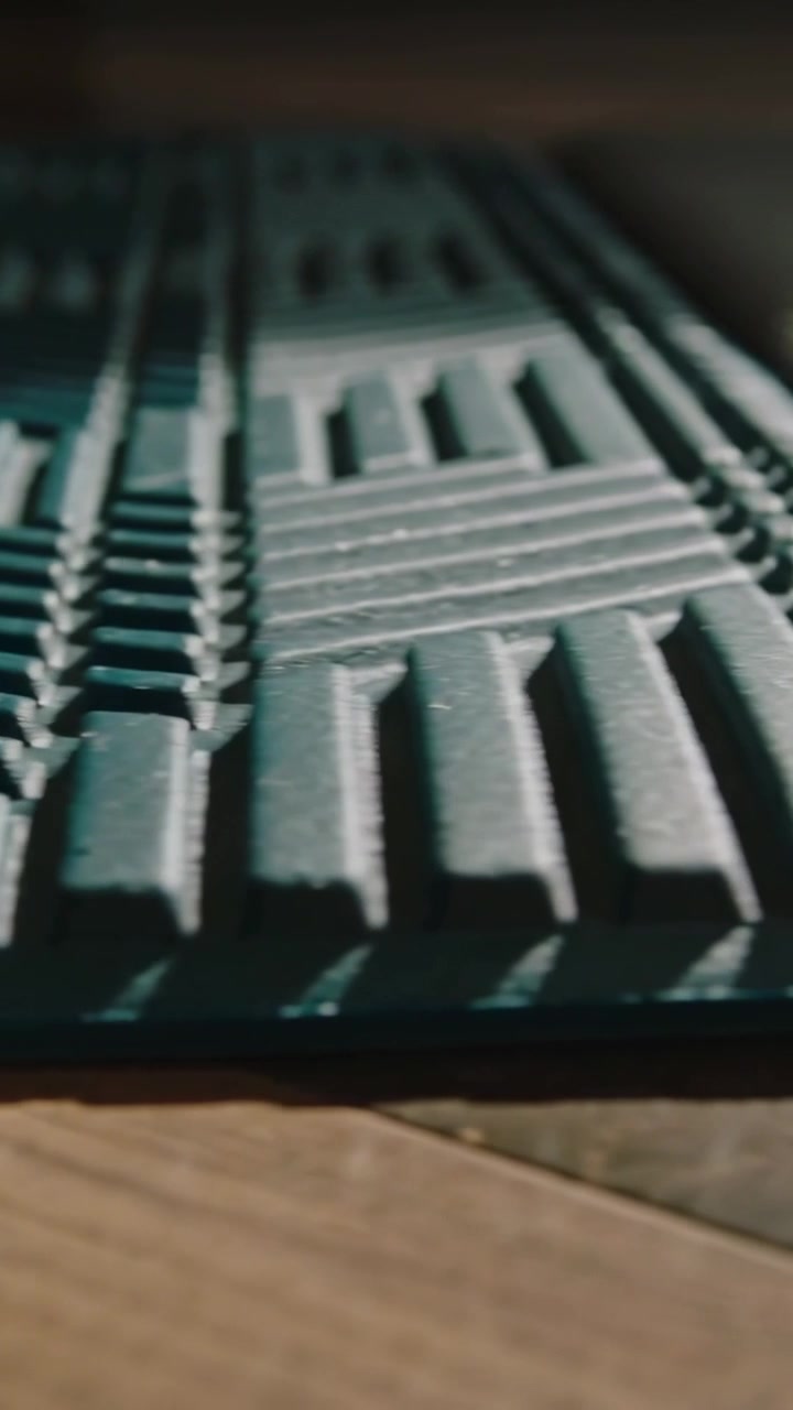 Vertical video: Panning camera from pad corner, showing teal ridges and gray mat on wood floor