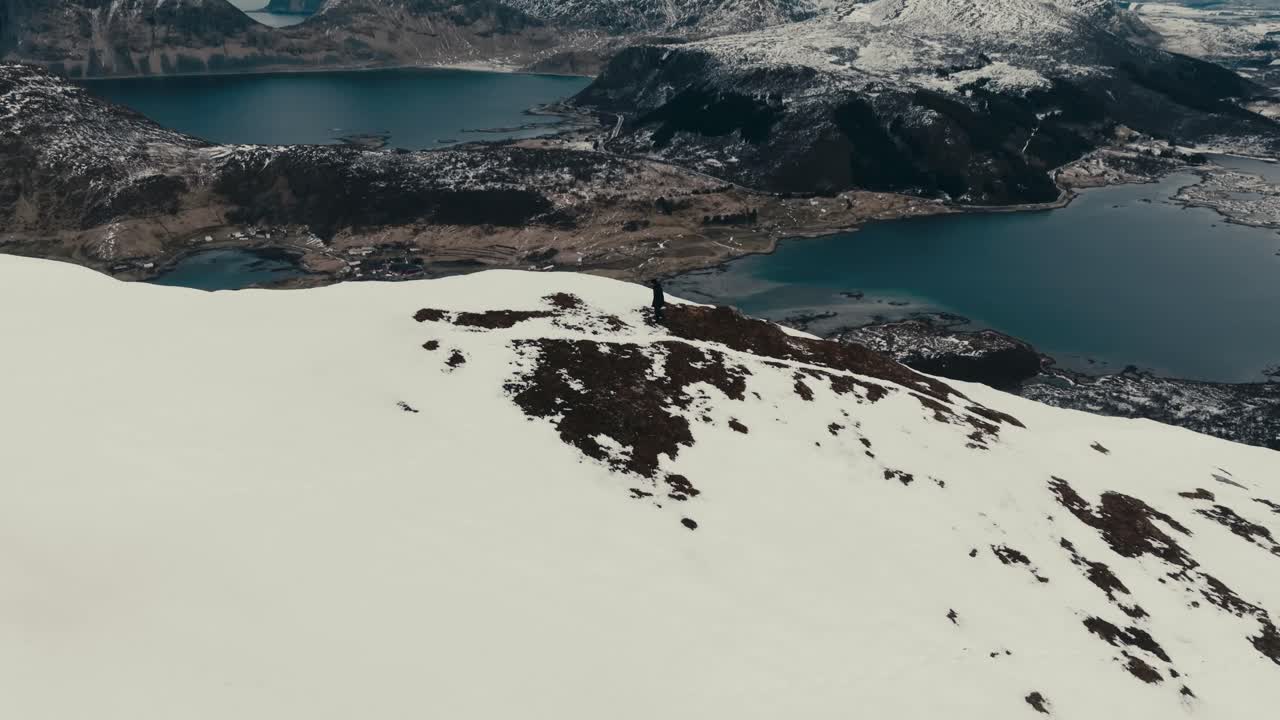 A Man Over Offersoykammen Peak On Vestagoya Island In Lofoten Archipelago In Norway. Aerial Pullback Shot