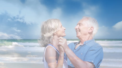 Animation-of-glowing-light-over-happy-senior-couple-dancing-by-seaside