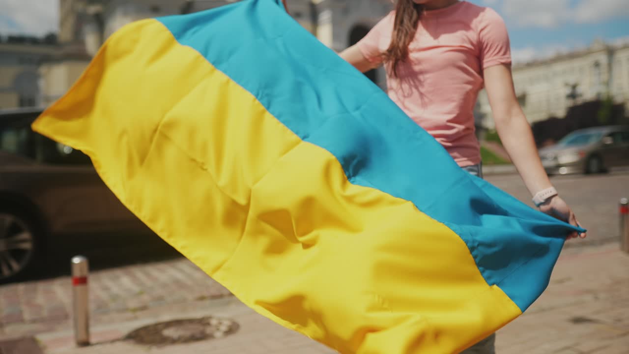 거리에서 우크라이나 발을 들고 있는 젊은 여성