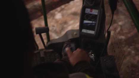 first person pov blue collar tradesman operates industrial timber logging manipulator arm claw tractor from inside cabin with joystick-2