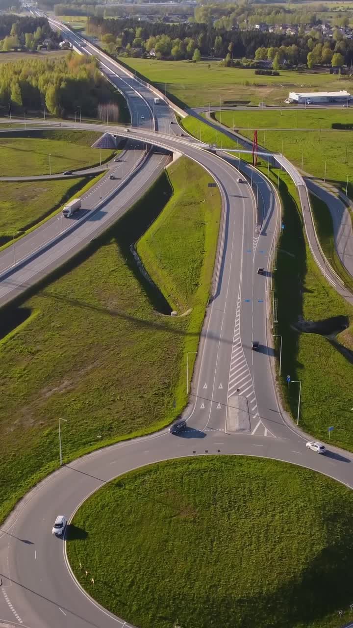 Highway road with multi level junction and green landscape of Latvia, aerial vertical view