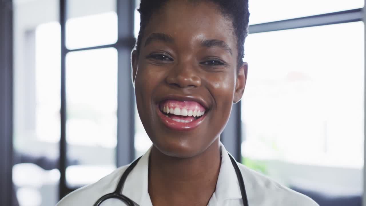 Retrato de médica afro-americana olhando para a câmera e sorrindo