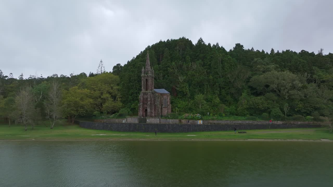 Vista aerea di una suggestiva vecchia chiesa in riva al lago nel bosco a São Miguel, Azzorre, che domina un paesaggio aspro