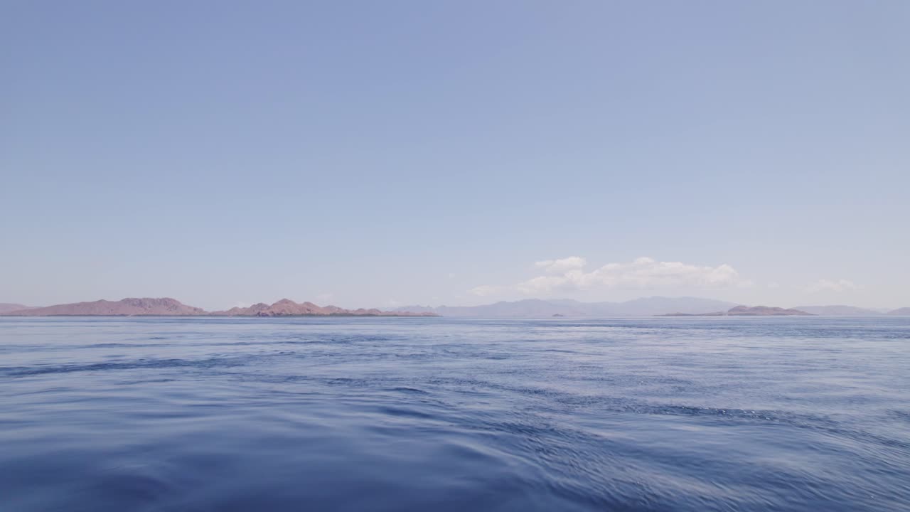 코모도 섬을 향해 날아가는 배 활에 서있는 남자에 의한 빠른 공중 비행