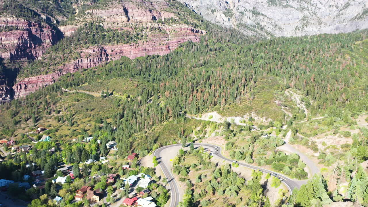 воздушный дрон восходящее движение красивого ouray колорадо сосновый лес и горные утесы с автомобилями, едущими по шоссе 550 мимо домов скалистых гор
