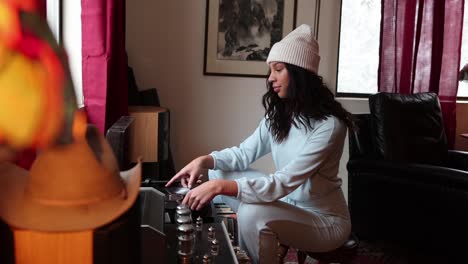 a young woman changes the disc on a record player