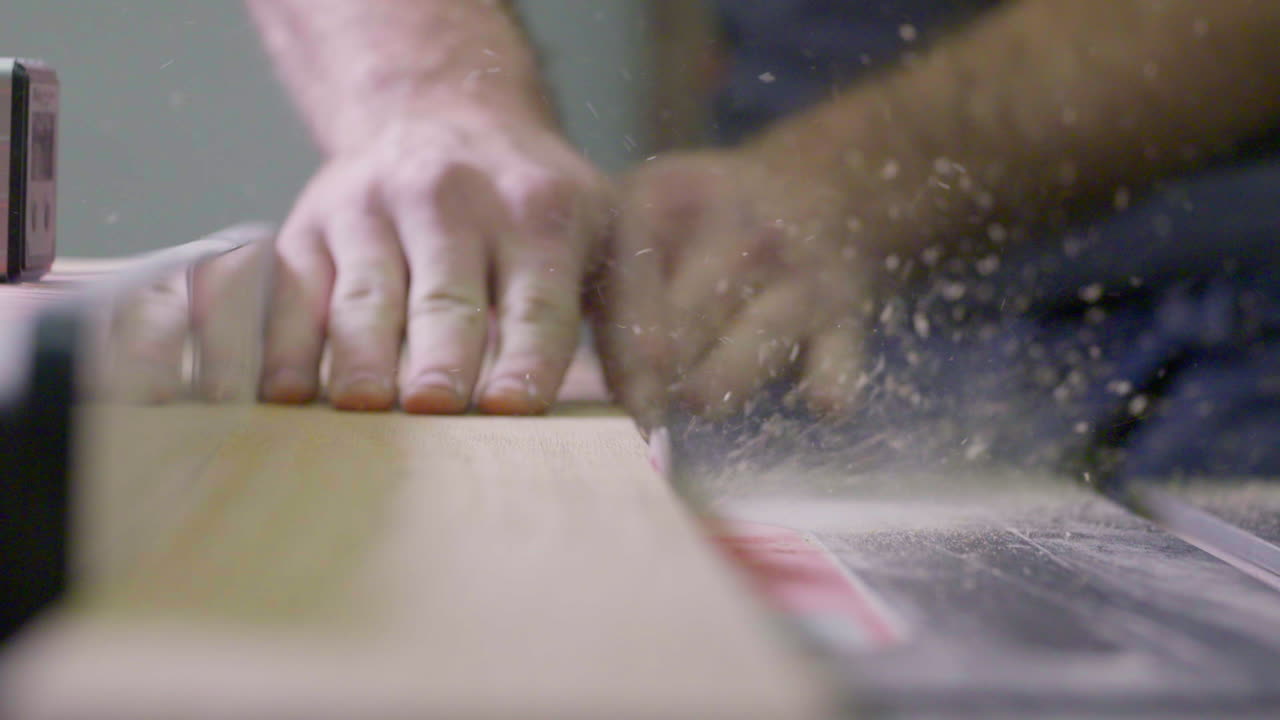 hombre corta madera en una sierra de mesa en su tienda