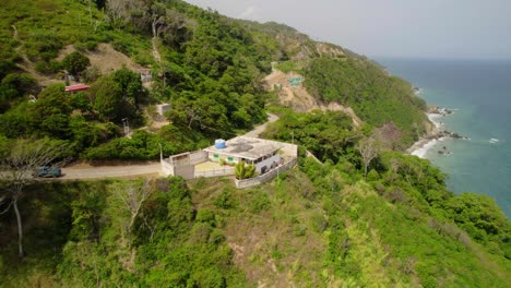 mountain house by the tropical coast with a car driving on a hillside road above the caribbean sea, la guaira