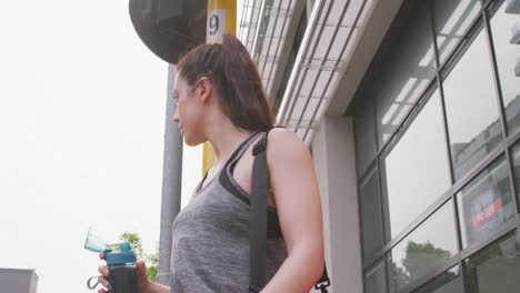 caucasian woman walking with a yoga mat