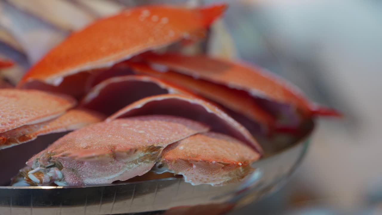 Pan right then left, A bowl of stacked empty cooked orange crab shells ready to be made into seafood stock