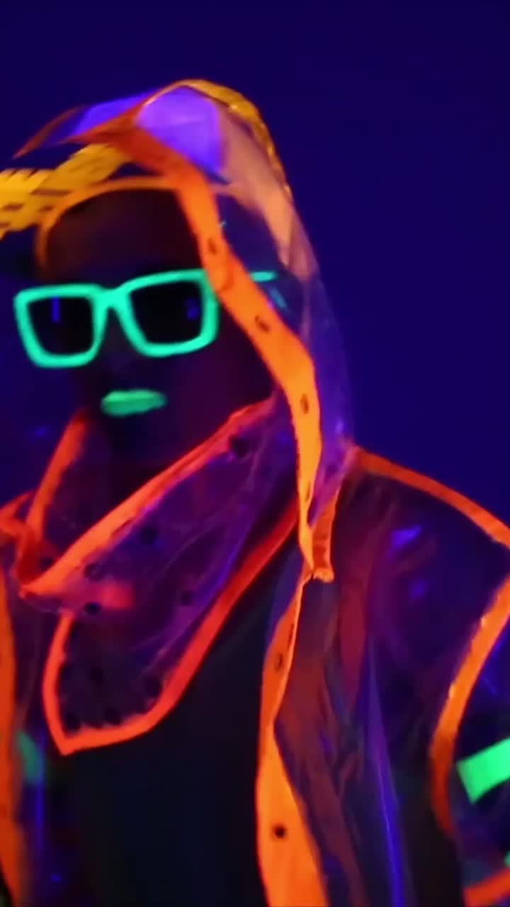 Person i neon-glødende outfit under UV-lys