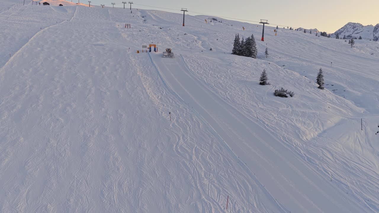 Riprese aeree della Zillertal Arena che mostrano gatti delle nevi che modellano le piste da sci a Krimml e Königsleiten, Austria, con neve alta e cime alpine panoramiche
