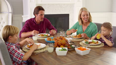 family sitting around table eating meal shot on r3d