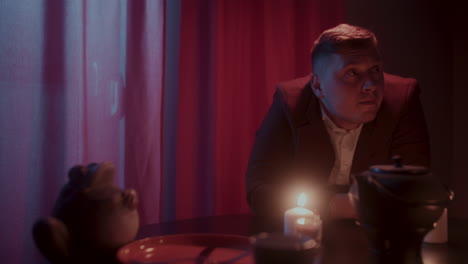 man sitting at a table in a dimly lit room