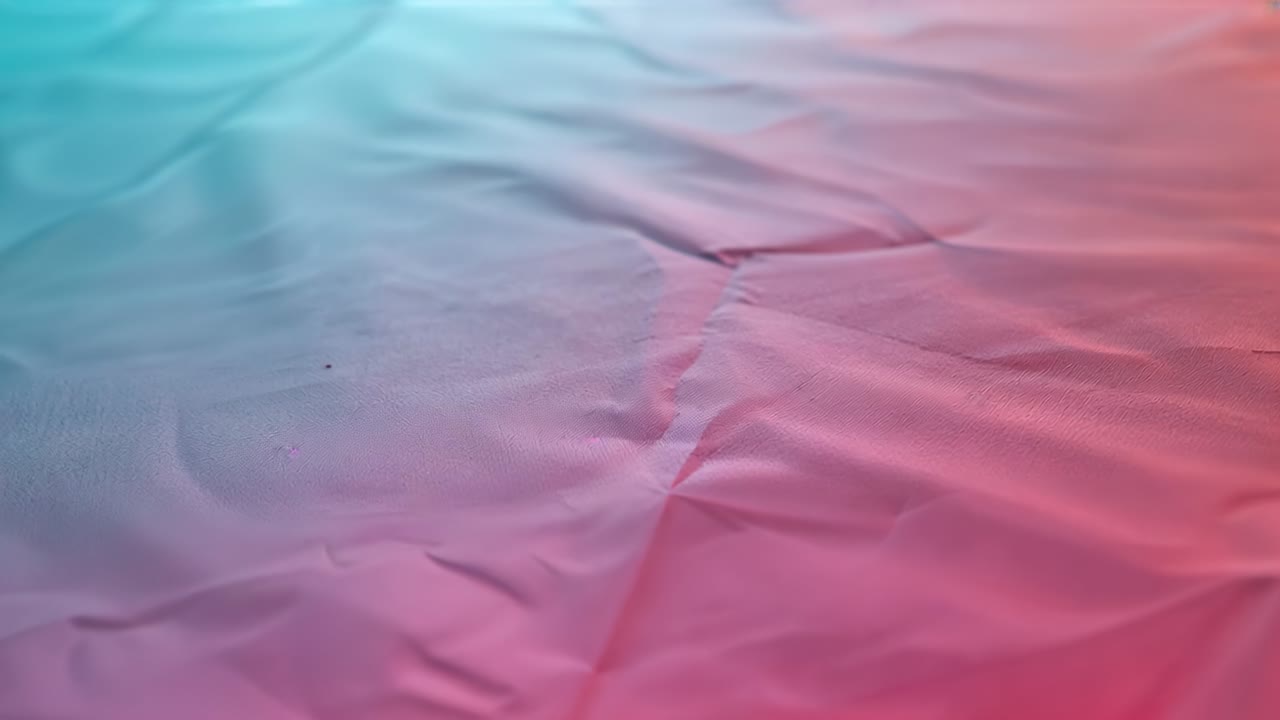 Rising satin sheet forming ridge from left lift and rolling across table, teal pink gradient, speck