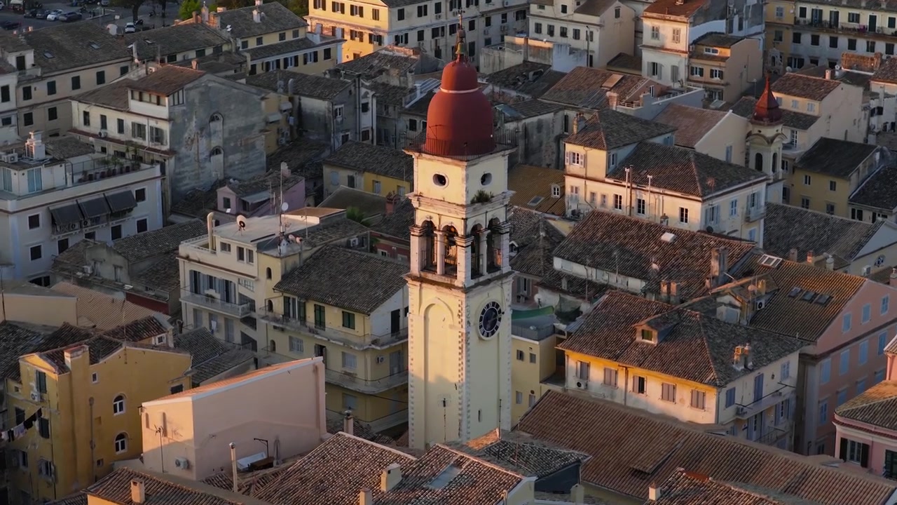 Densa città mediterranea a Corfù con luce calda mattutina, Campanile di San Spiridione all'alba.