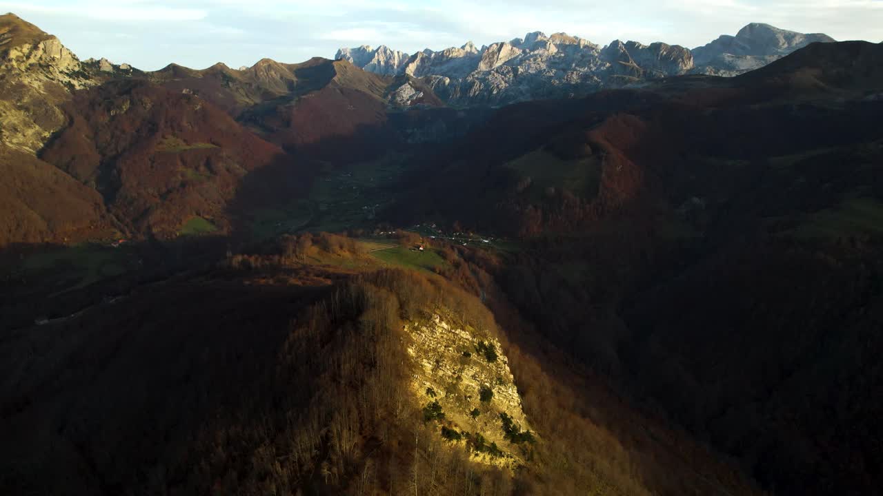 puesta de sol sobre montañas alpinas y valles con hierba verde rodeada de bosques en otoño, albania