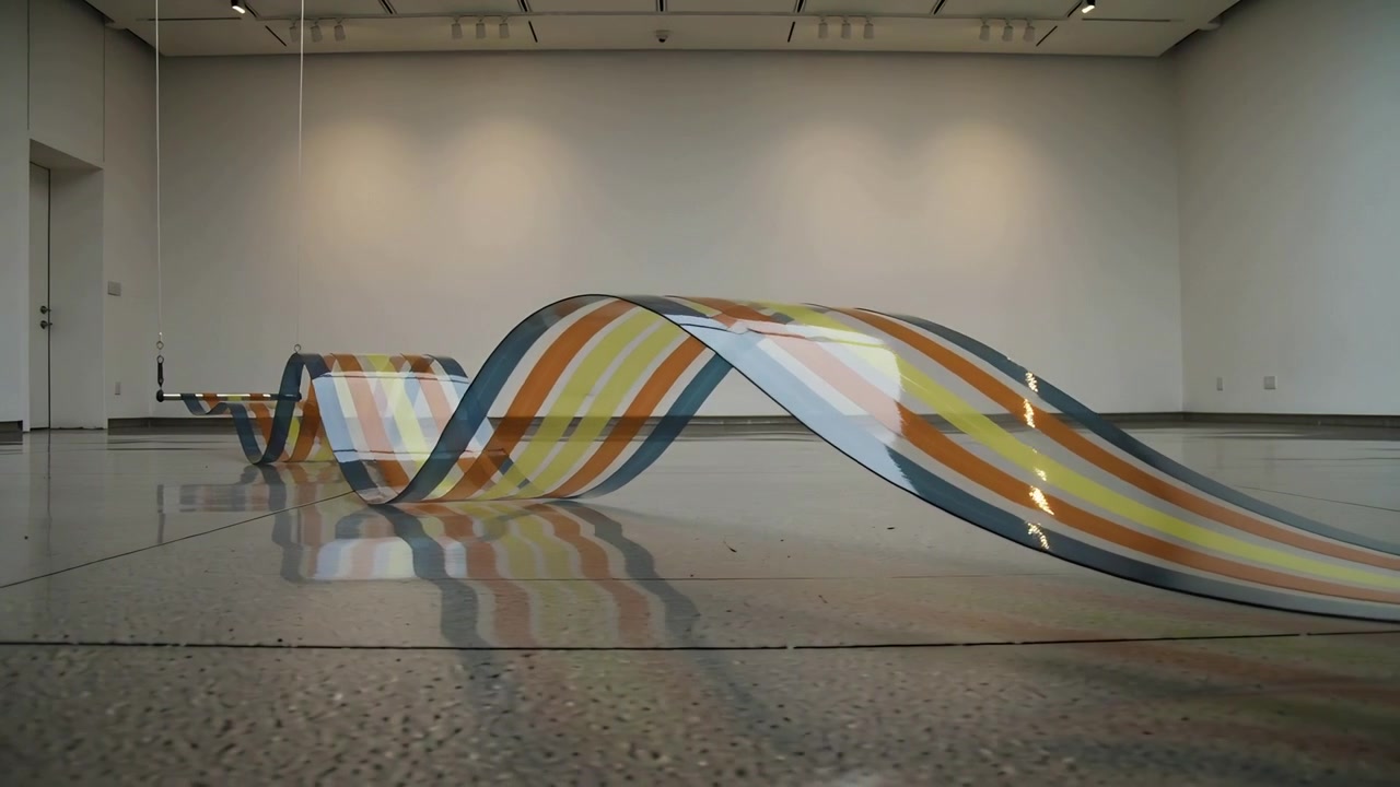 Undulating striped ribbon forming traveling wave, crest growing on gallery floor, mirroring swing
