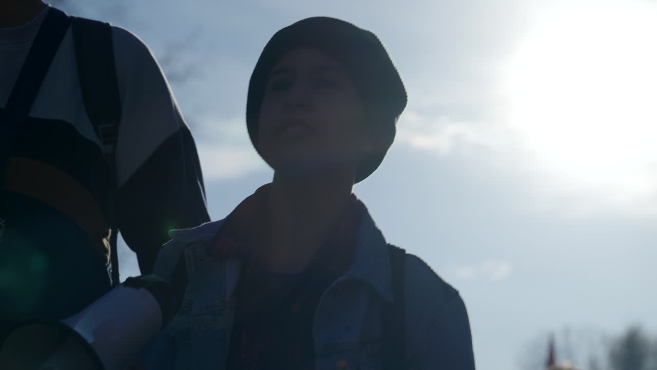 공개 모임에서 확성기 확성기를 들고 춤을 추는 백라이트 어린 십대 소녀, 슬로우 모션