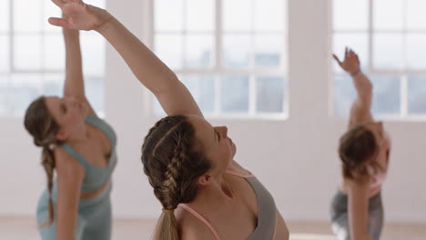 hermosa mujer de yoga practicando pose de guerrero inverso en el gimnasio entrenamiento femenino caucásico con instructor grupo de mujeres disfrutando de un estilo de vida saludable y equilibrado