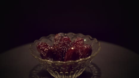 high quality texture medjool dates in spinning glass bowl under spotlight