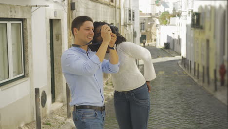 happy tourists with photo camera taking pictures of old city.