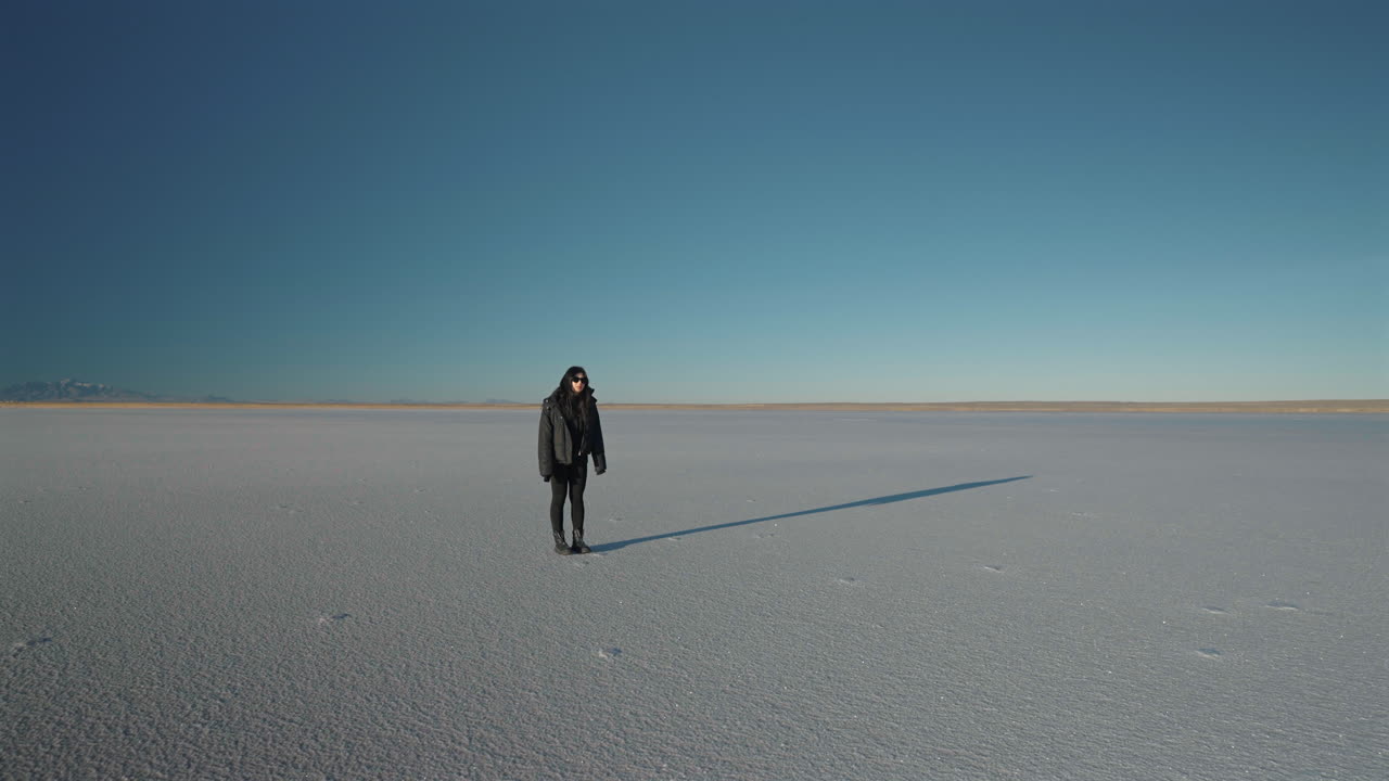 Mother and young daughter running toward each other and hugging on an expansive desert salt lake, expressing love, family bond, joy, freedom, and connection within a minimal natural landscape