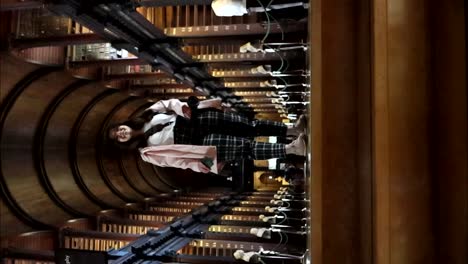 Woman-smiles-inside-The-Long-Room-in-The-Old-Library,-Dublin