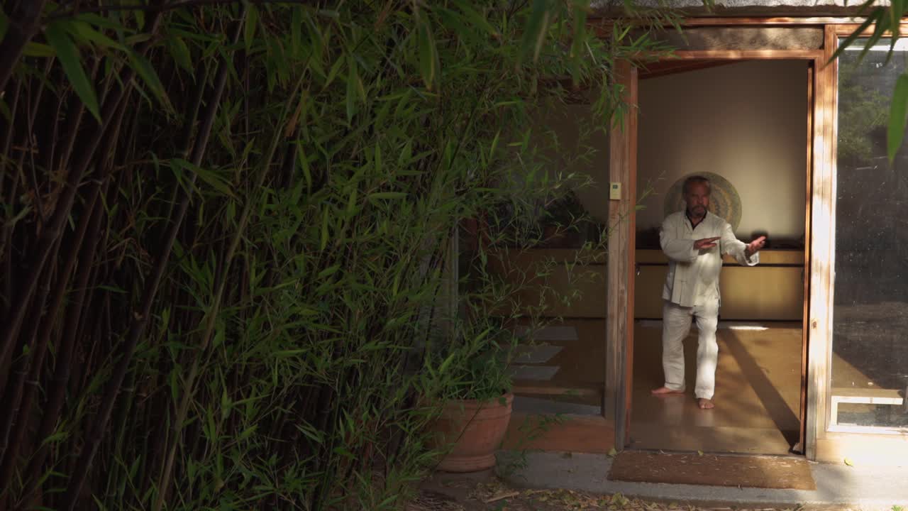 Man performing chi kung exercise in spacious room