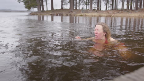 Frau-Schwimmt-Im-Zugefrorenen-See-Und-Macht-Atemübungen,-Therapeutisches-Eisbad