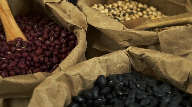 Rich, narrow focus close up: Assorted dry beans rotating in paper bags